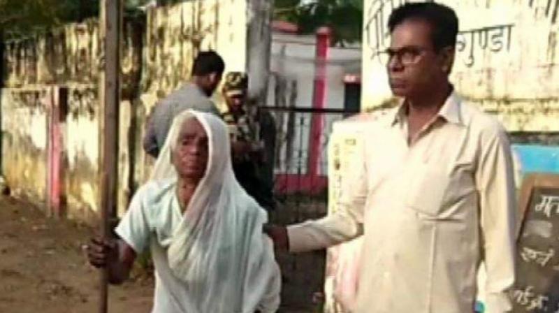 The old woman was helped by her son as she visited the polling booth set up near her house. (Photo: ANI) The old woman was helped by her son as she visited the polling booth set up near her house. (Photo: ANI)
