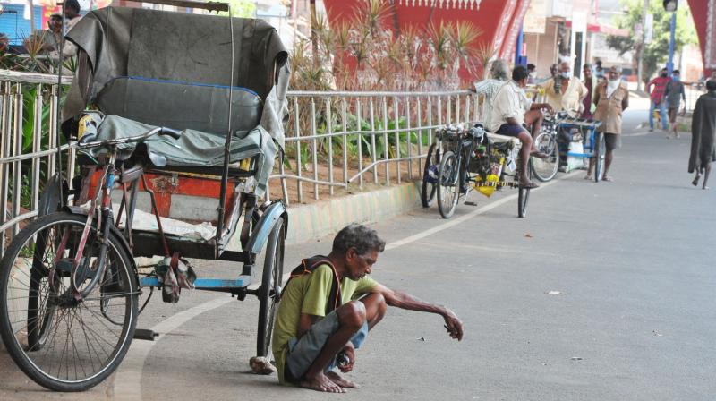 Rickshaw pullers in forlorn wait for custom under the shade of the Asilmetta flyover in Visakhapatnam. (DC Photo: P Narasimha Murthy)