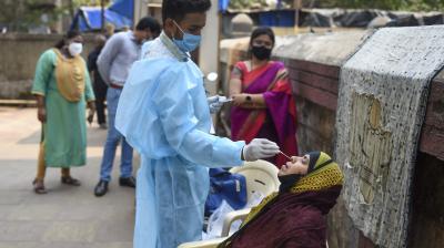  A health worker takes swab sample of a resident for COVID-19 testing in a housing society, amid a surge in coronavirus cases, at Nehru Nagar in Mumbai, Thursday, Feb. 18, 2021. (PTI)