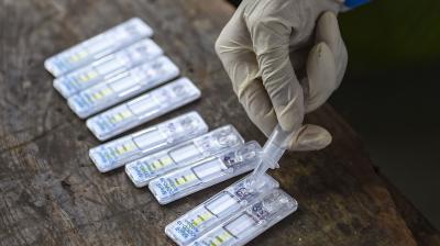 A health worker collects swab samples of passengers for COVID-19 test at Dadar Railway platform, in Mumbai. (PTI)