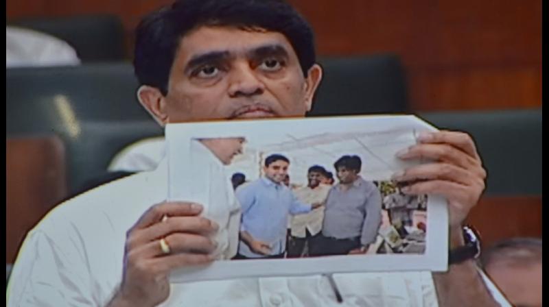 Minister Buggana shows a photograph alleging TD leader Lokesh