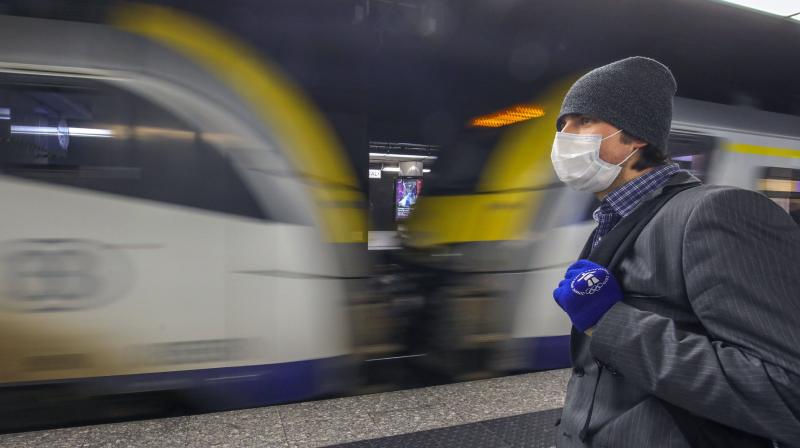 A man wearing a protective mask waits for a train at the nearly empty Central station in Brussels. AP Photo A man wearing a protective mask waits for a train at the nearly empty Central station in Brussels. AP Photo