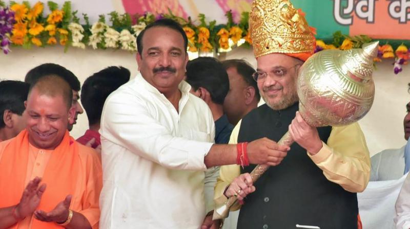 Congress MLC Dinesh Pratap Singh presents a memento to BJP president Amit Shah in the presence of Uttar Pradesh chief minister Yogi Adityanath at a rally in Rae Bareli on Saturday. (Photo: PTI) Congress MLC Dinesh Pratap Singh presents a memento to BJP president Amit Shah in the presence of Uttar Pradesh chief minister Yogi Adityanath at a rally in Rae Bareli on Saturday. (Photo: PTI)