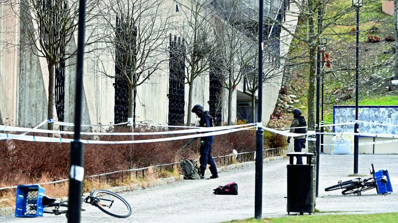 A Swedish policeman searches the area outside a Stockholm metro station