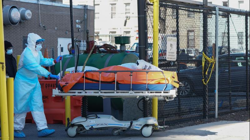 A body is moved to a refrigerator truck serving as a temporary morgue outside of Wyckoff Hospital in the Borough of Brooklyn, New York. AFP Photo