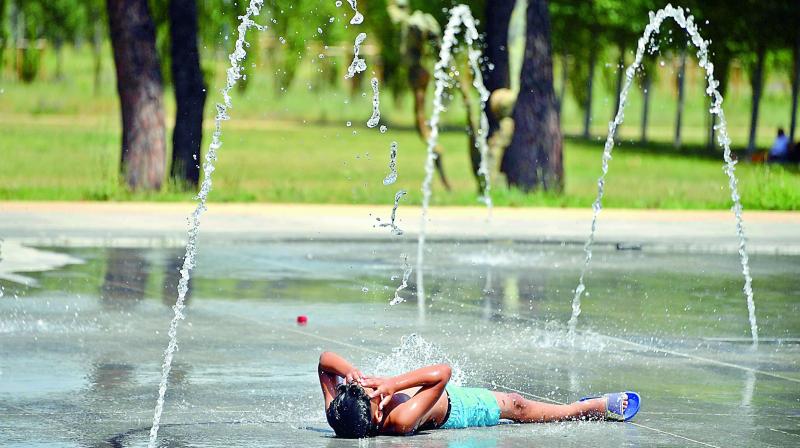 A boy lies on the pavement as he cools off at a fountain in Montpellier, southern France, during a heat wave. (Photo: AFP) A boy lies on the pavement as he cools off at a fountain in Montpellier, southern France, during a heat wave. (Photo: AFP)
