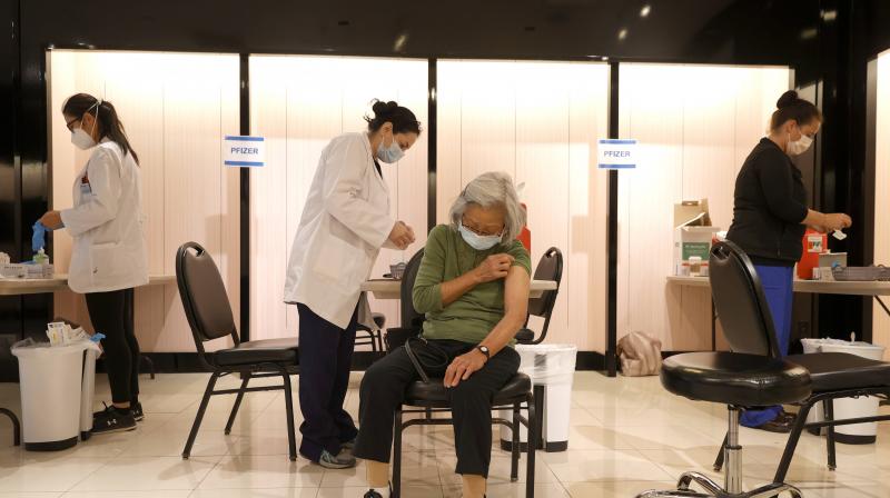 Safeway pharmacist Shahrzad Khoobyari (L) prepares to give a Pfizer COVID-19 booster vaccination to Chen Knifsend (R) at a vaccination booster shot clinic on October 01, 2021 in San Rafael, California. (Justin Sullivan/Getty Images/AFP)
