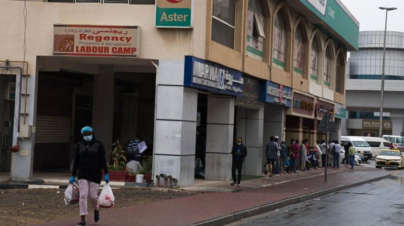 A line of laborers wait outside a medical clinic in the Al Quoz neighborhood of Dubai, United Arab Emirates. Migrant workers in oil-rich Gulf Arab states find themselves trapped by the coronavirus pandemic. They are losing jobs, running out of money and desperate to return home as the coronavirus, stalks their labor camps. An unknown number of workers have contracted the virus or have suddenly been forced into mass quarantines, leaving them exposed and painfully vulnerable with little recourse for help. (AP Photo) A line of laborers wait outside a medical clinic in the Al Quoz neighborhood of Dubai, United Arab Emirates. Migrant workers in oil-rich Gulf Arab states find themselves trapped by the coronavirus pandemic. They are losing jobs, running out of money and desperate to return home as the coronavirus, stalks their labor camps. An unknown number of workers have contracted the virus or have suddenly been forced into mass quarantines, leaving them exposed and painfully vulnerable with little recourse for help. (AP Photo)