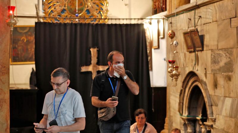 People wearing masks visit the Church of the Nativity, revered as the birthplace of Jesus Christ, in the West Bank city of Bethlehem.