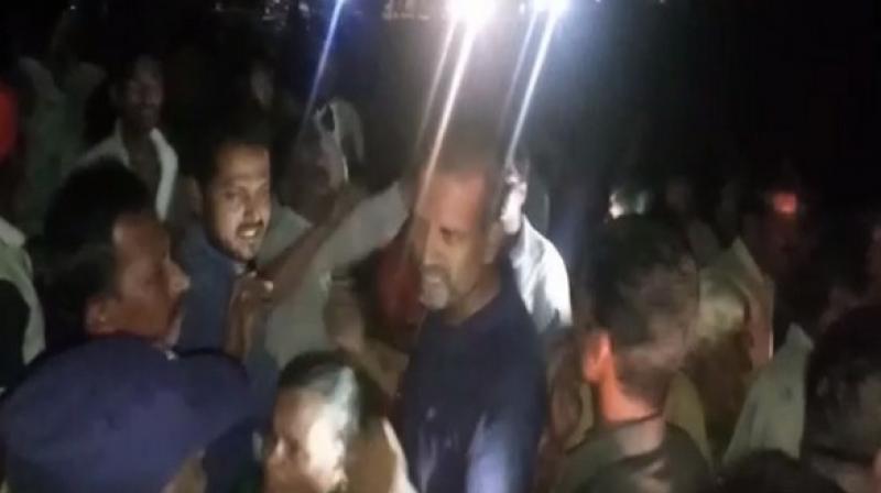 Women tried to attack Mohit Reddy with broom sticks. He sat at the entrance of the village to stage a protest. (Photo: ANI) Women tried to attack Mohit Reddy with broom sticks. He sat at the entrance of the village to stage a protest. (Photo: ANI)