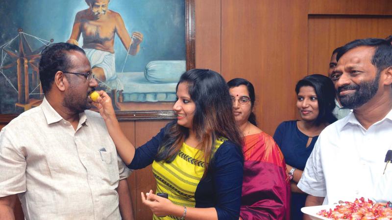 C.N. Mohanan, new Greater Cochin Development Authority (GCDA) chairman, gets sweets from his daughter after his taking charge on Monday. (Photo: DC) C.N. Mohanan, new Greater Cochin Development Authority (GCDA) chairman, gets sweets from his daughter after his taking charge on Monday. (Photo: DC)