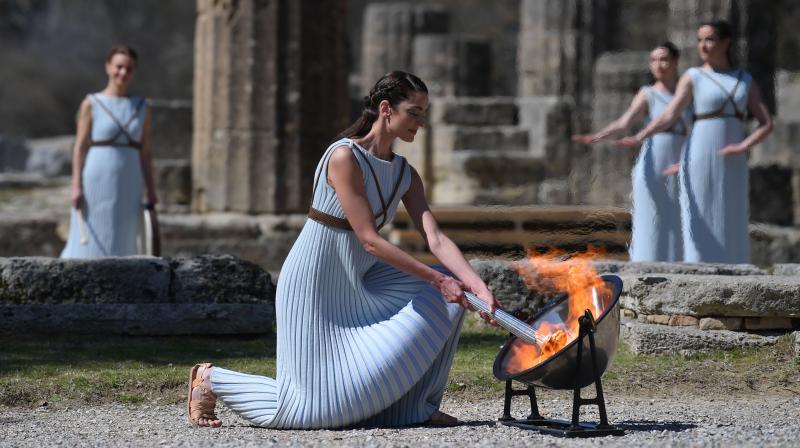 The Olympic flame being lit by a woman dressed as a priestess in ancient Olympia, Greece, on Thursday. AFP Photo