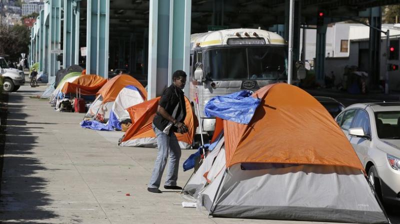 A man stands outside his tent on Division Street in San Francisco. (AP Photo/Eric Risberg, File) A man stands outside his tent on Division Street in San Francisco. (AP Photo/Eric Risberg, File)