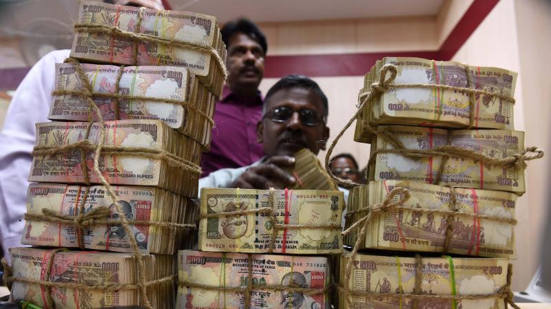 A bank employee counting the bundles of the received currency of old 1000 & 500 notes at cash counter at a Punjab National Bank branch in Chennai. (Photo: PTI) A bank employee counting the bundles of the received currency of old 1000 & 500 notes at cash counter at a Punjab National Bank branch in Chennai. (Photo: PTI)