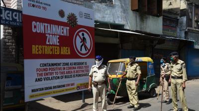Gujarat police personnel wearing facemasks stand guard near a board reading 'Containment Zone restricted area' during a government-imposed nationwide lockdown as a preventive measure against the COVID-19 coronavirus, in Ahmedabad. AFP Photo