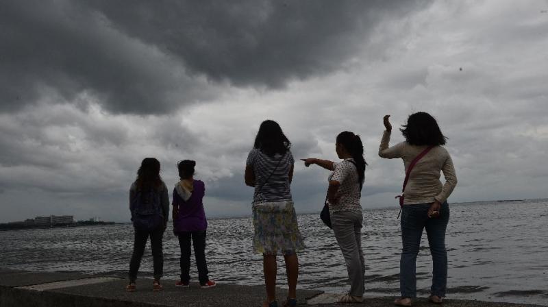 People watch as storm clouds gather around Manila Bay on October 16, 2016, after Typhoon Sarika passed north of the capital overnight. (Photo: AFP) People watch as storm clouds gather around Manila Bay on October 16, 2016, after Typhoon Sarika passed north of the capital overnight. (Photo: AFP)