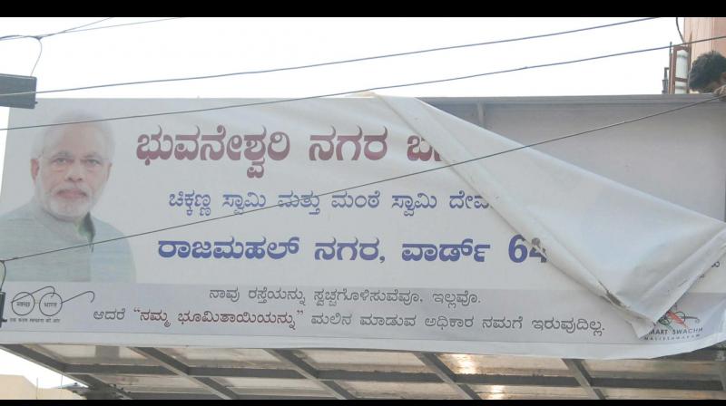 As code of conduct is on, BBMP workers removing a hoarding of MP Sadanandagowda at Rajmahal Nagar in Bengaluru on Saturday —KPN As code of conduct is on, BBMP workers removing a hoarding of MP Sadanandagowda at Rajmahal Nagar in Bengaluru on Saturday —KPN