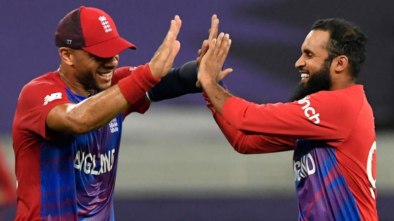 Englands Adil Rashid (R) celebrates with teammate Tymal Mills after taking the wicket of West Indies Obed McCoy (not pictured) during the ICC mens Twenty20 World Cup cricket match between England and West Indies at the Dubai International Cricket Stadium in Dubai on Saturday. (Photo: AFP)