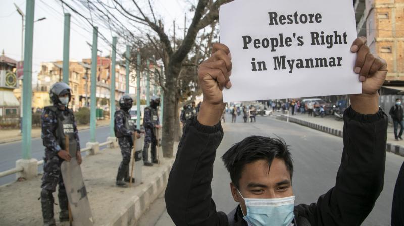 Policemen stand guard as a Nepalese Civil society activist holds a placard reacting to the developments in Myanmar during a protest in Kathmandu, Nepal, Monday, February 1, 2021. (AP/Niranjan Shrestha) Policemen stand guard as a Nepalese Civil society activist holds a placard reacting to the developments in Myanmar during a protest in Kathmandu, Nepal, Monday, February 1, 2021. (AP/Niranjan Shrestha)