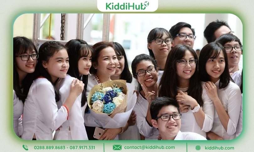 Tập thể học sinh chụp ảnh cùng cô giáo, trên tay cầm hoa chúc mừng