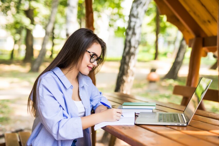 tired woman using laptop park table end day 1