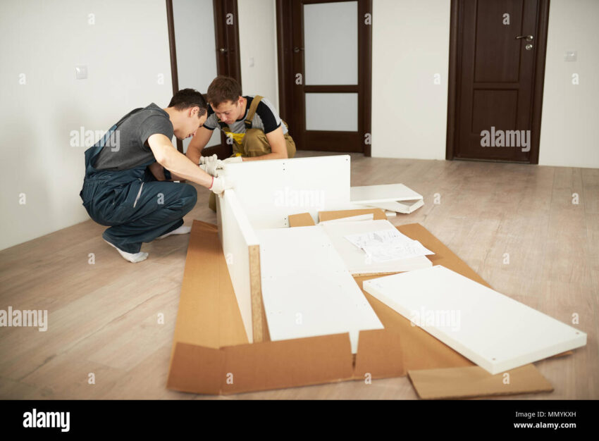 two professional workers installing furniture in apartment furniture installation service MMYKXH