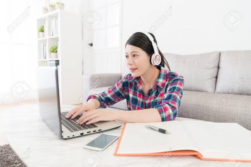 92269434 attractive sweet college student using computer keyboard typing doing online test exam and wearing