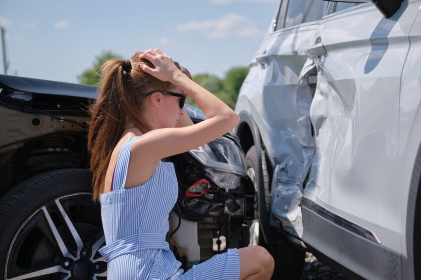 woman looking at car that needs quarter panel repair