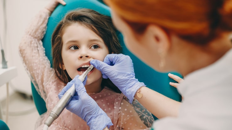 lovely little girl looking pediatric dentist while having teeth examination pediatric stomatology 129180 2825
