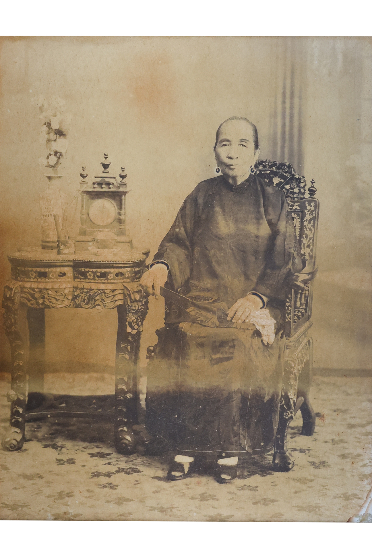 A LARGE-FORMAT PHOTOGRAPHIC PORTRAIT OF A SEATED NYONYA