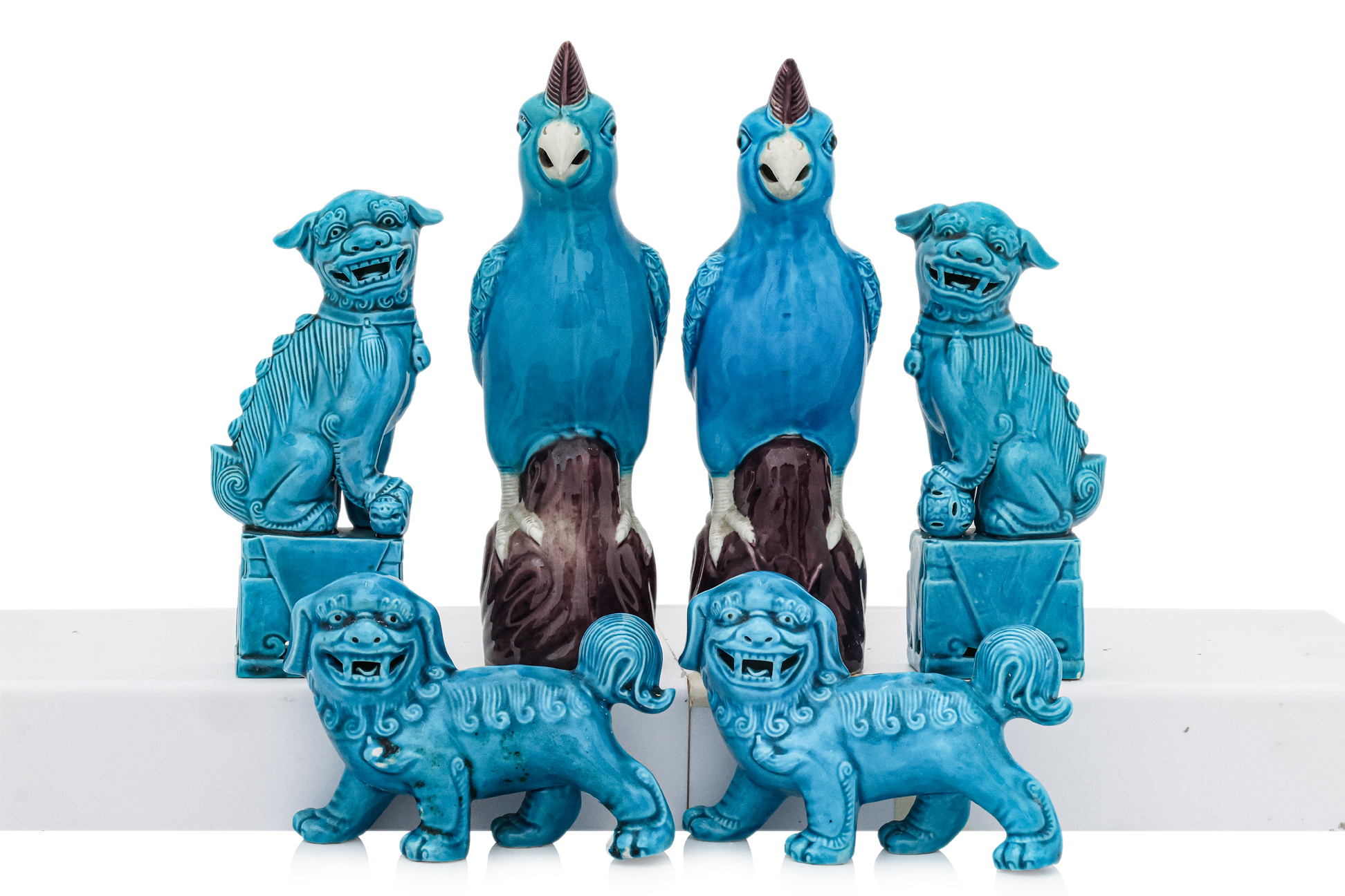 A GROUP OF FOUR TURQUOISE-GLAZED FOO LIONS AND A PAIR OF PARROTS