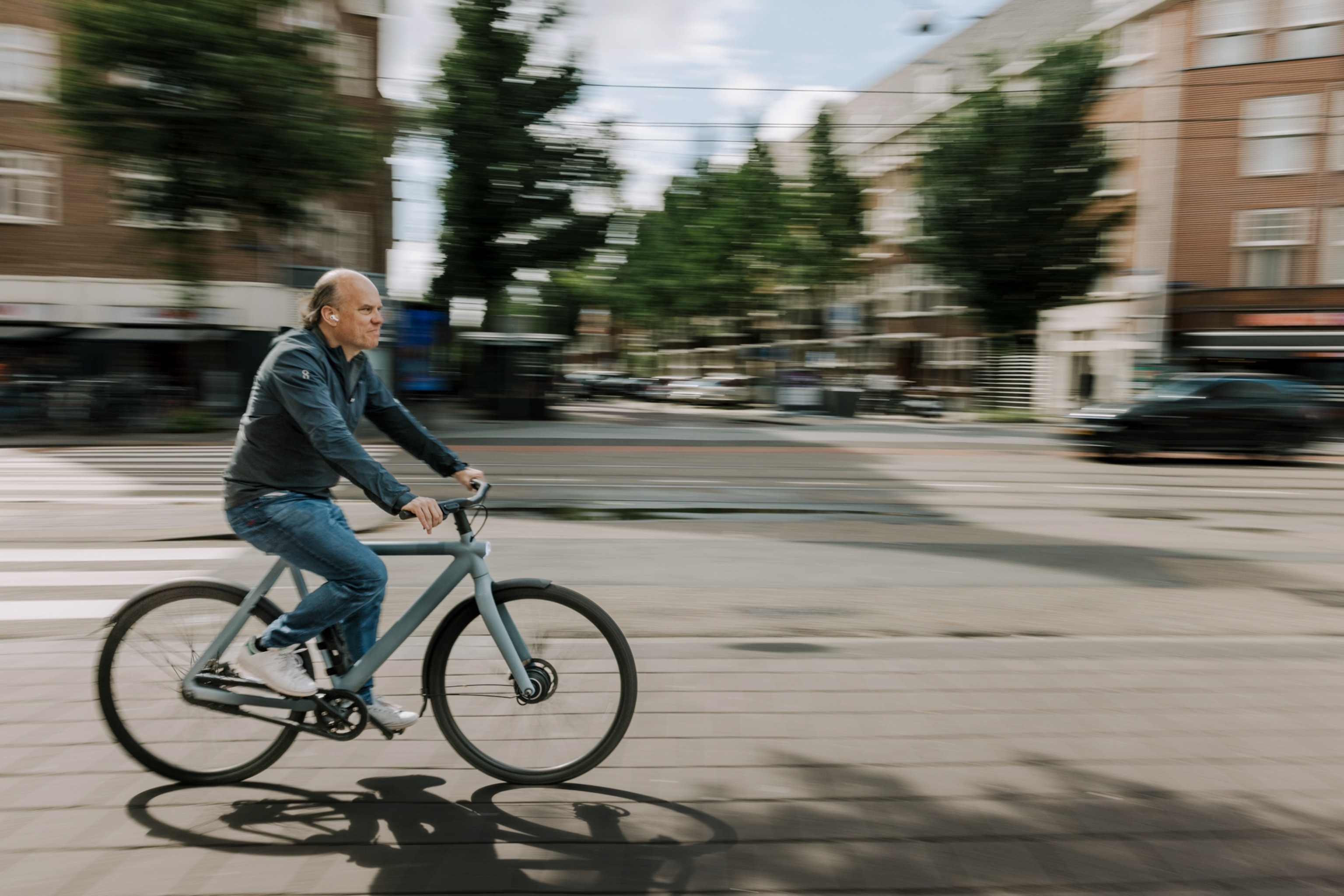 A person riding an e-bike on a path surrounded by lush greenery, symbolizing eco-friendly transport.
