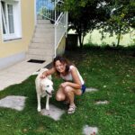 girl petting a dog in the backyard of the house