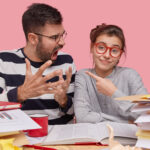 indoor shot pretty woman points angry boyfriend blames him failure study together prepare final test college read textbook pose coworking space 1 optimized 2000