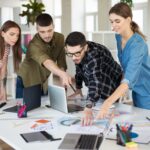 young creative people with laptop sketches discussing new project together group guys gals working modern cozy office 1