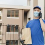 medium shot delivery man holding bag