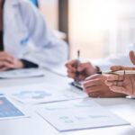 team medical analysts doctors consulting with paperwork graphs data charts hospital conference room closeup healthcare staff discussing statistics results innovation strategy 590464 83574