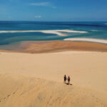 couple holding hands sand dune bazaruto island