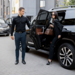 stock photo male driver helps a business lady to get out of a car opening door of a luxury suv taxi business 2389405899 ezremove