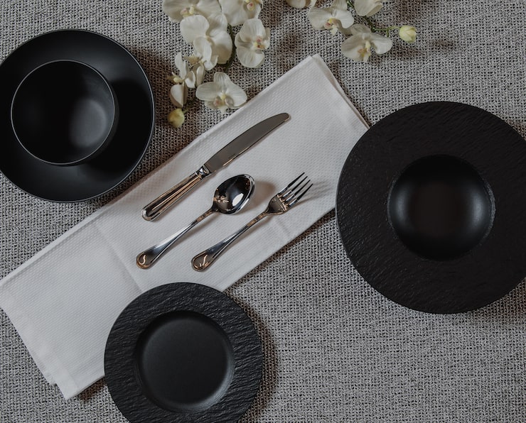 top view table setting gey surface with empty black plates silver spoon fork knife 140725 12953