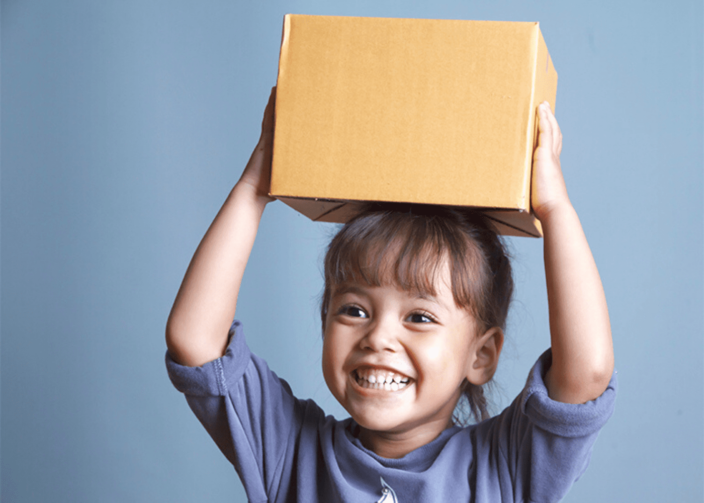 girl holding a box over her head