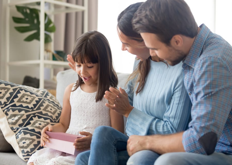 parents giving kid a gift