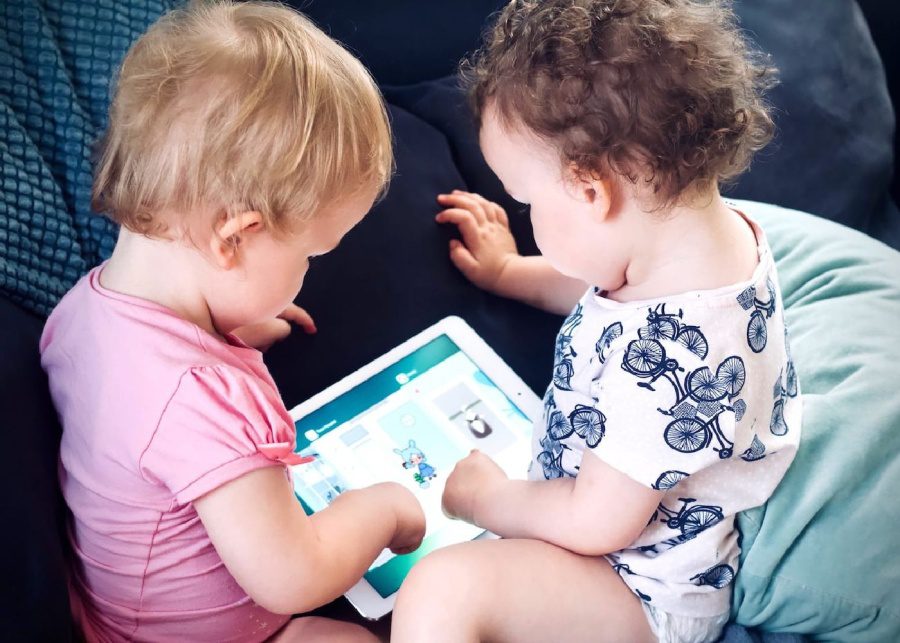 two kids playing with apps on ipad