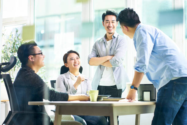 image of a group of singaporeans and malaysians discussing at a table in a digital agency