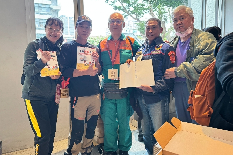 活動學員與日本防災士松井正雄先生合影留念,並邀請其於防災教材上簽名,象徵臺日防災交流與知識傳承。