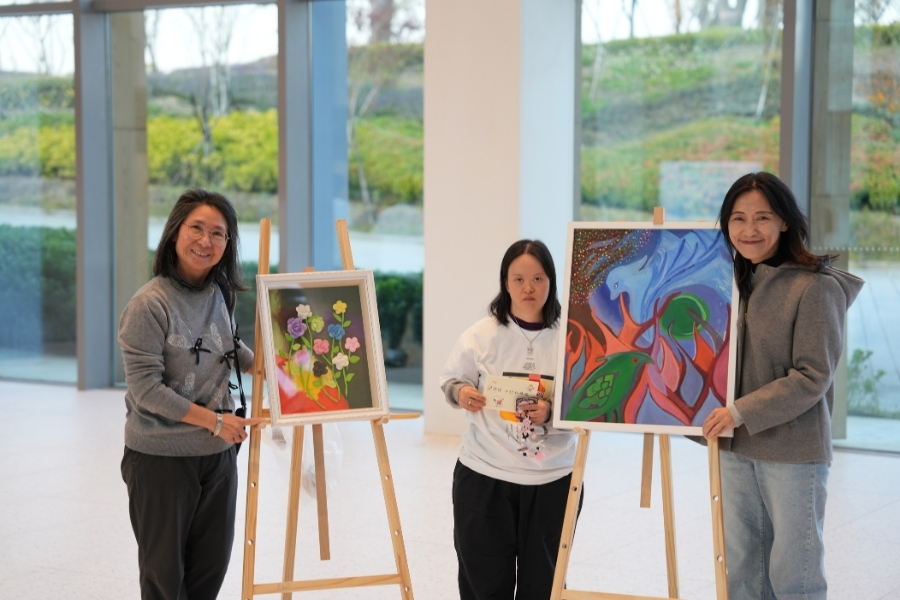 成果展特地邀請唐氏症畫家陳舒妏(中)展示個人畫作，呈現藝術家對生命的熱情與獨特的創作視角。