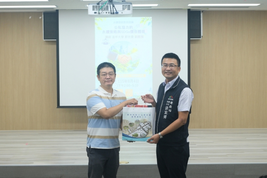 臺中市政府地政局簡任技正洪宏勇致贈禮品予逢甲永續處研究員劉世慶老師(左)。