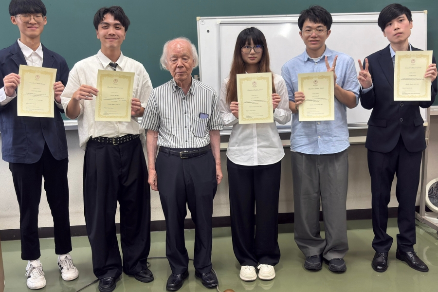 九州大學名譽教授河合良信頒獎表揚在全英文成果發表中表現優異的學生。