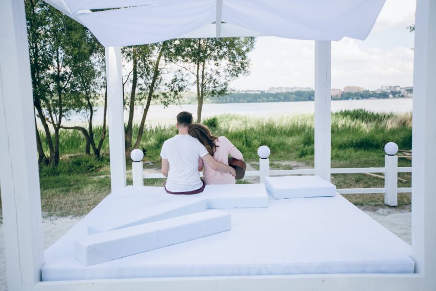compressed couple backs sitting bed with her head resting his shoulder