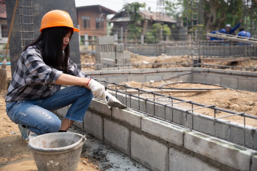 bricklayer worker installing brick masonry exterior wall with trowel putty knife 1